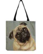 A dark gray colored canvas tote bag with a picture of Pug with his head tilted to the left woven black straps.