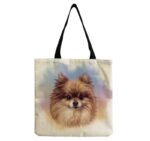 A natural colored canvas tote bag with a picture of Pomeranian on a blue, pink, and purple watercolor background.