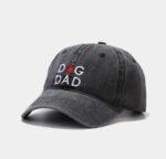 A vintage distressed dark gray baseball cap with "dog dad" written in white letters. The 'O' in "Dog" is a red pawprint.